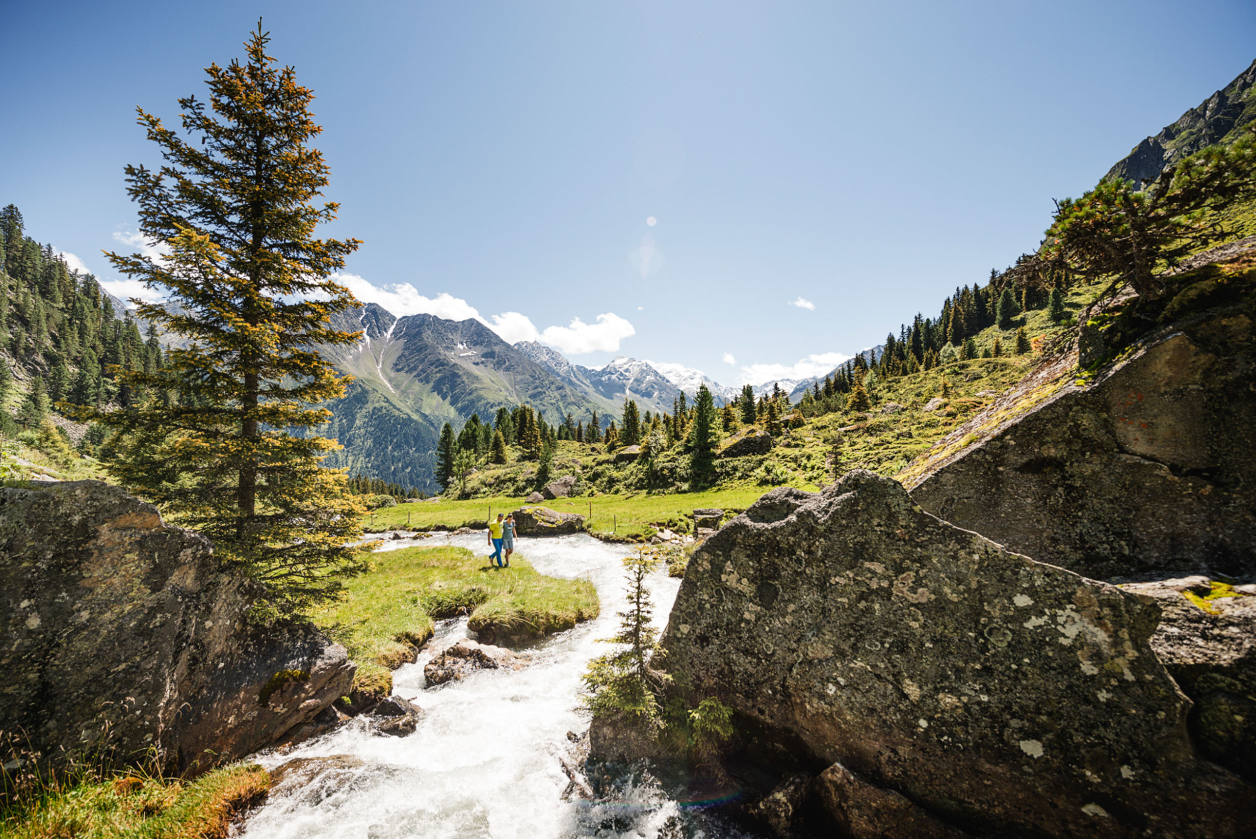 Ein Paar wandert entlang der Ruetz im Stubaital